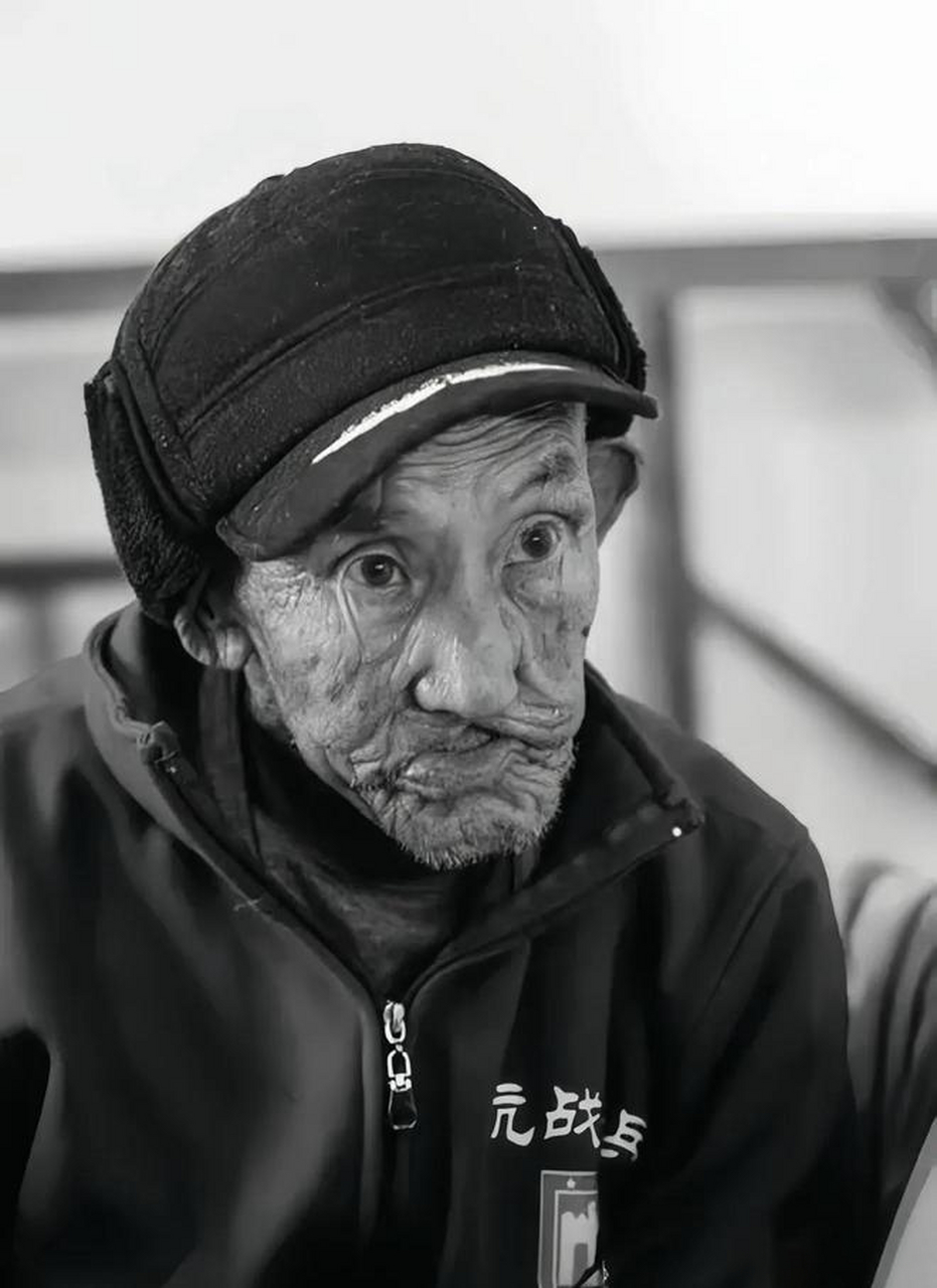 照片中的这位老人名叫谭春华,虽然脸上已布满皱纹,但他的眼神依旧坚毅