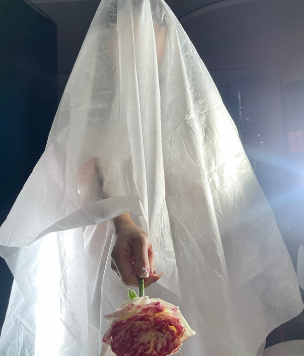 网红艾比晒婚纱照,头被头纱蒙着,手拿鲜花,却不见新郎身影