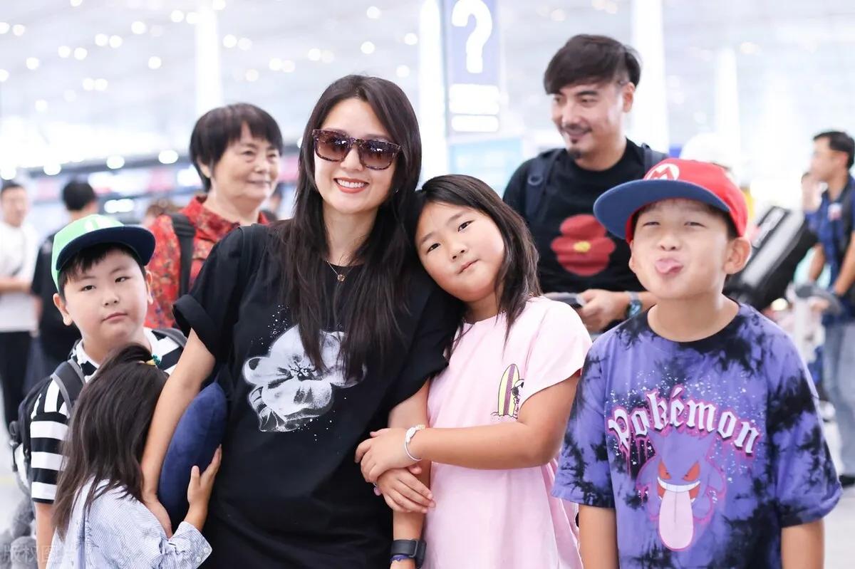 何洁一家五口现身机场,和仨孩子大方面对镜头拍照,画面温馨有爱