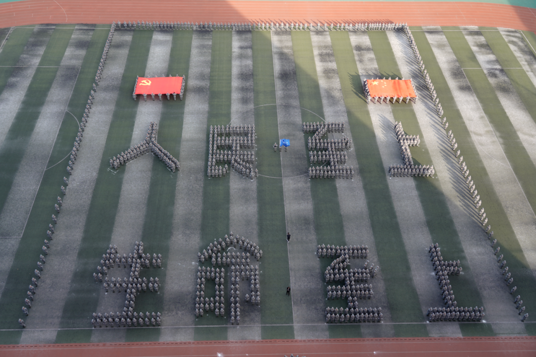 全体参训同学用身躯摆出"人民至上,生命至上"的字样,在党旗和国旗的