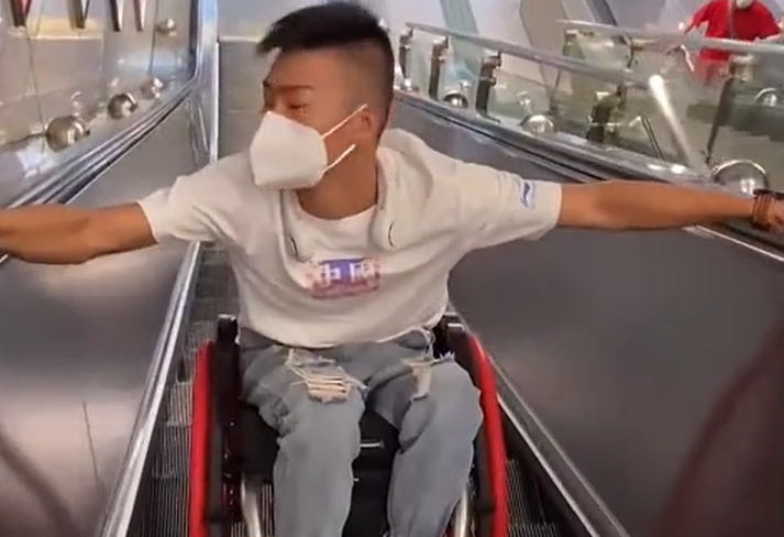广东一残疾小伙独自坐轮椅上电梯,双手吃力抓扶手,网友直接泪崩