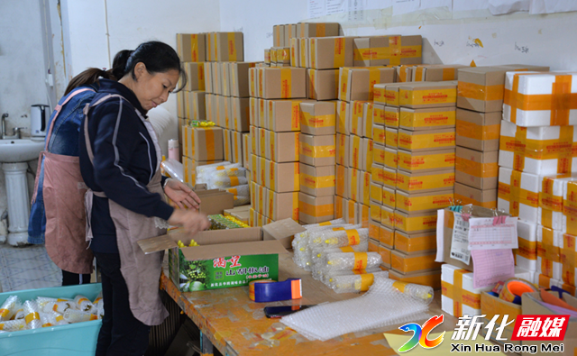 (洋梓商贸公司员工正在打包发货农产品)