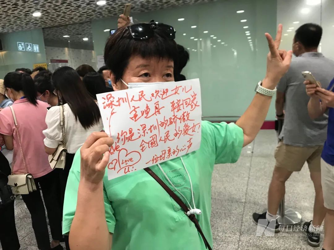 一位阿姨的接机牌上写着她的心声. 图片来源:每经记者 甄素静 摄