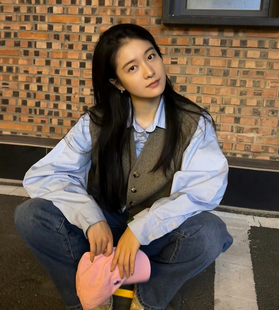 张雪迎蹲在停车位上搞怪拍照,穿着马甲衬衫特别干练,特别像现实中职场