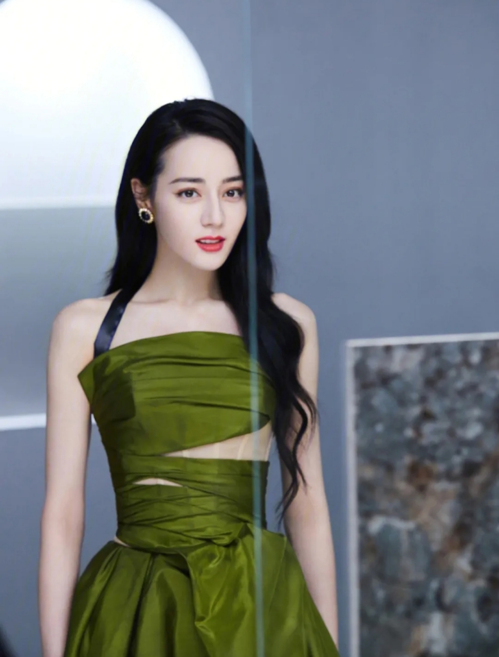 迪丽热巴一身墨绿色吊带连衣裙,完美的身材比例搭配大波浪造型,营造出