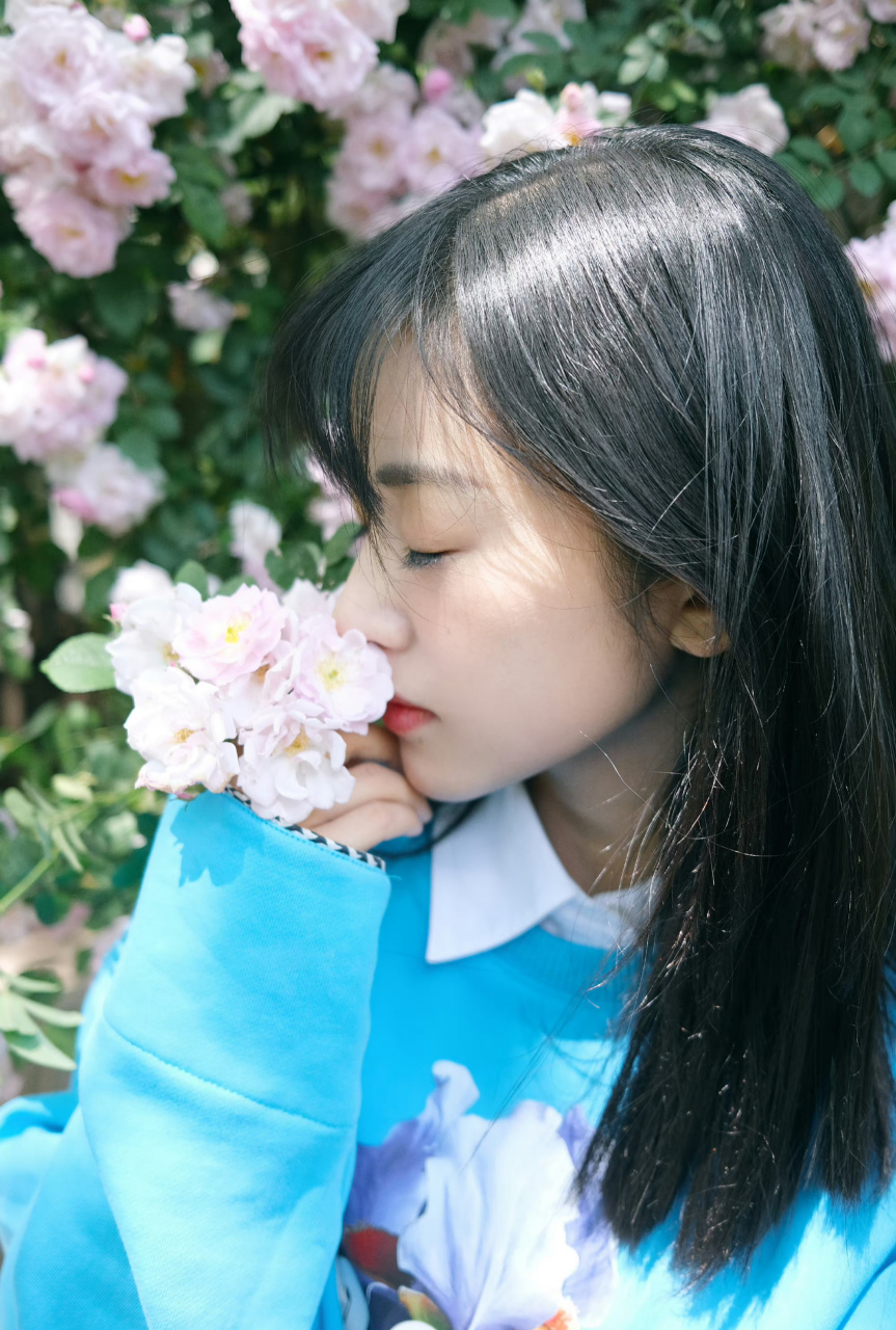 照片中,沈月身穿蓝色卫衣,手拿蔷薇花,好清新啊.