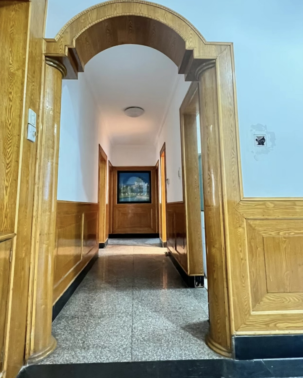 这是八九十年代典型的装修风格,水磨石地板,白色的墙面和木质的门框