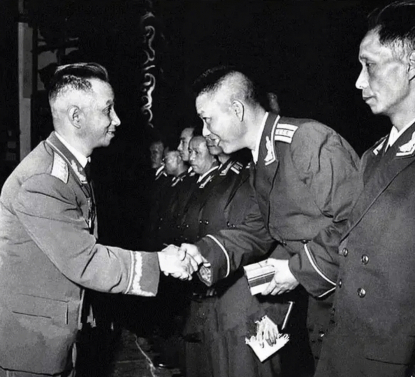 1955年,北京,粟裕正在为军区军官们授衔的照片,画面中粟裕正在跟每个