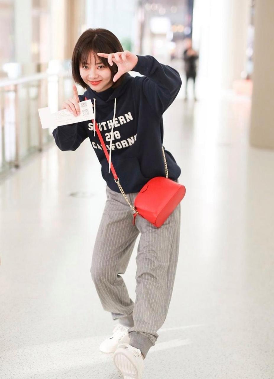 谭松韵太可爱了,穿着帽衫,休闲裤,斜挎着红色包包,面对镜头做鬼脸的