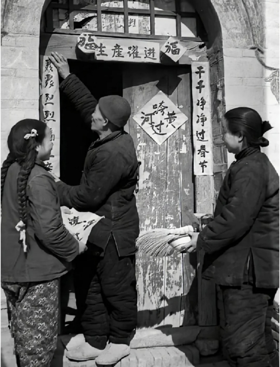 生产队时期的老照片,过年了,一户农家正在贴对联,对联内容很有特色!