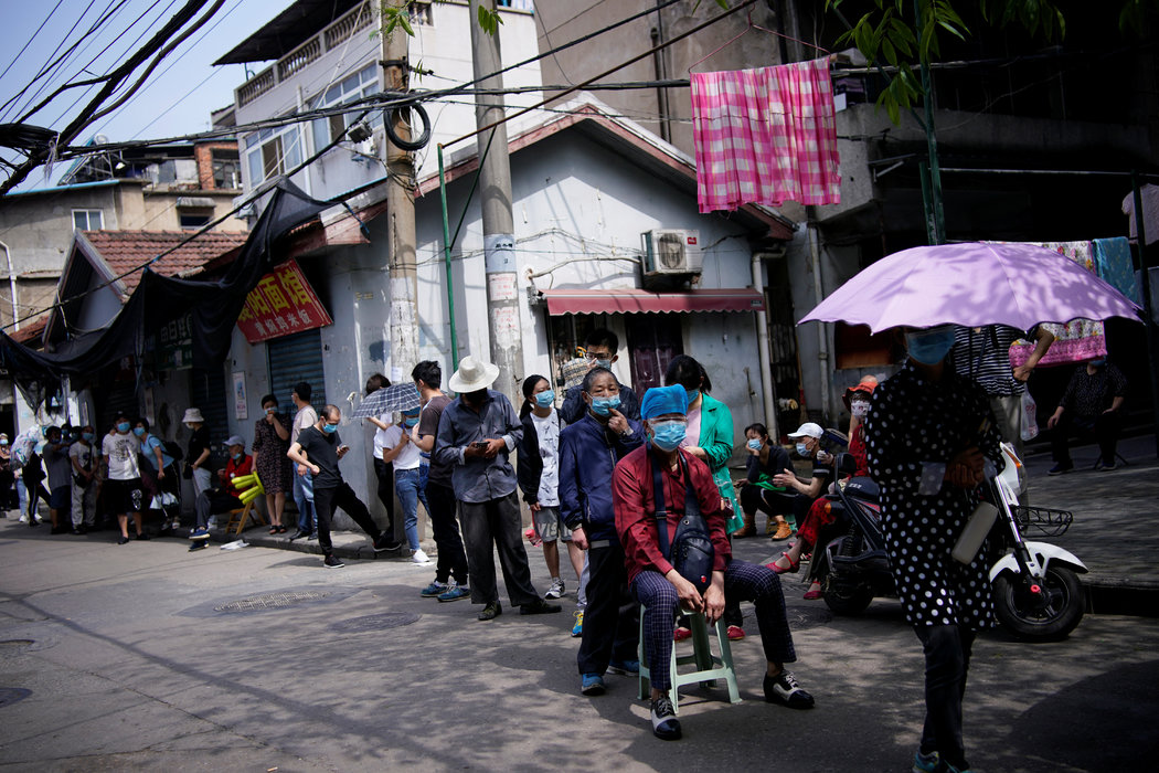 上个月,疫情暴发地武汉的一处居民区,人们等待接受新冠病毒检测。