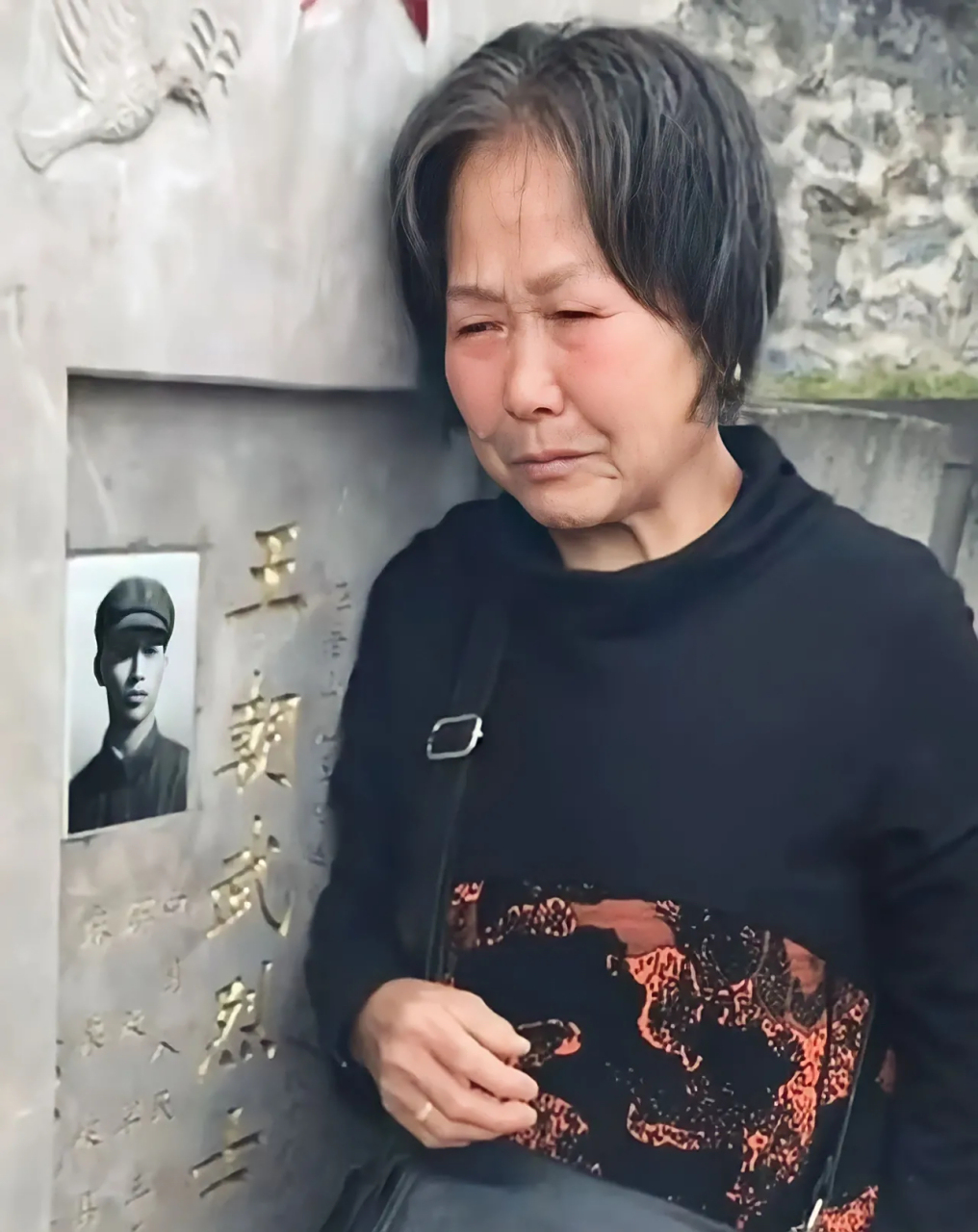 在云南省麻栗坡烈士陵园,一位年迈的母亲在儿子的墓碑前面痛哭流涕
