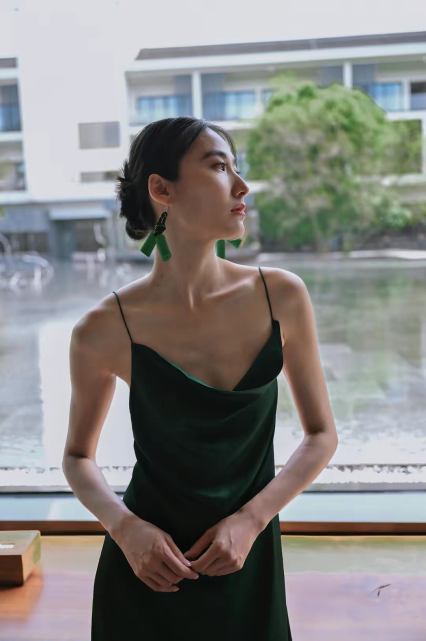 国际名模王诗晴晒穿搭写真,绿色低胸吊带大露背长裙,亭亭玉立