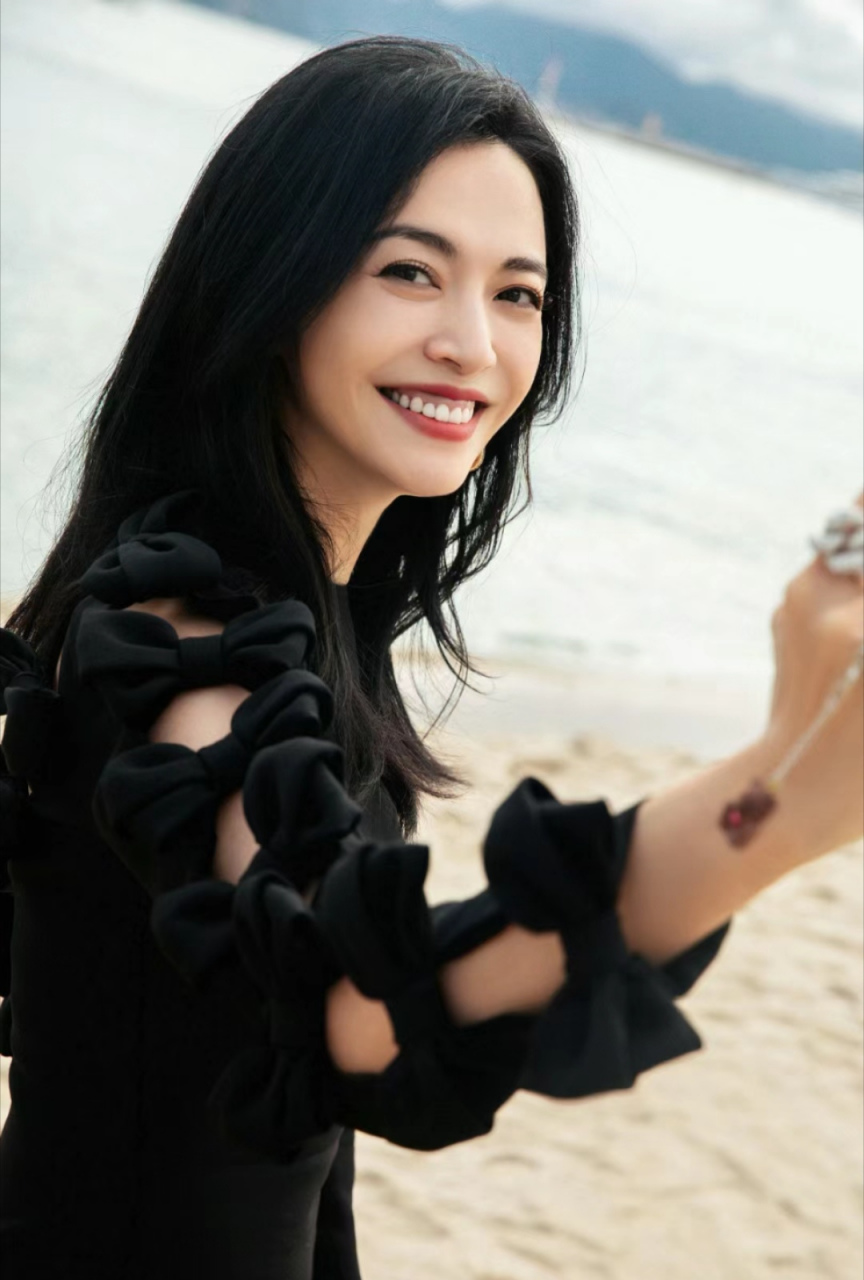 沙滩上提着高跟鞋沙滩 搭配黑色丝袜 美景与美女 很好的展现出姚晨