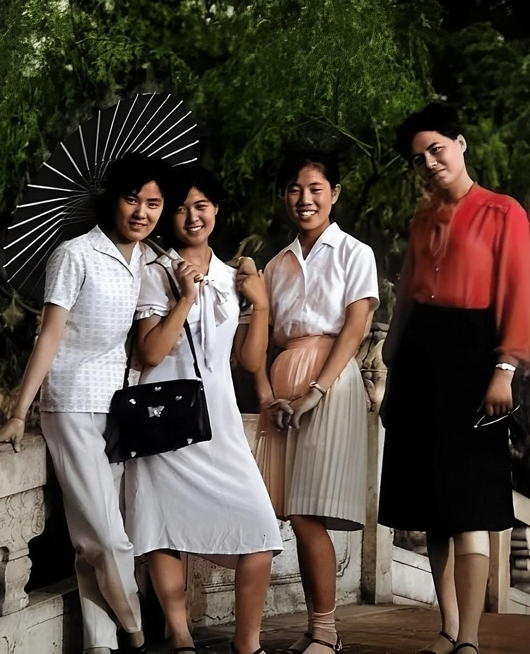 上海一张20世纪80年代的老照片显示,穿着时髦的女孩在公园里撑着油