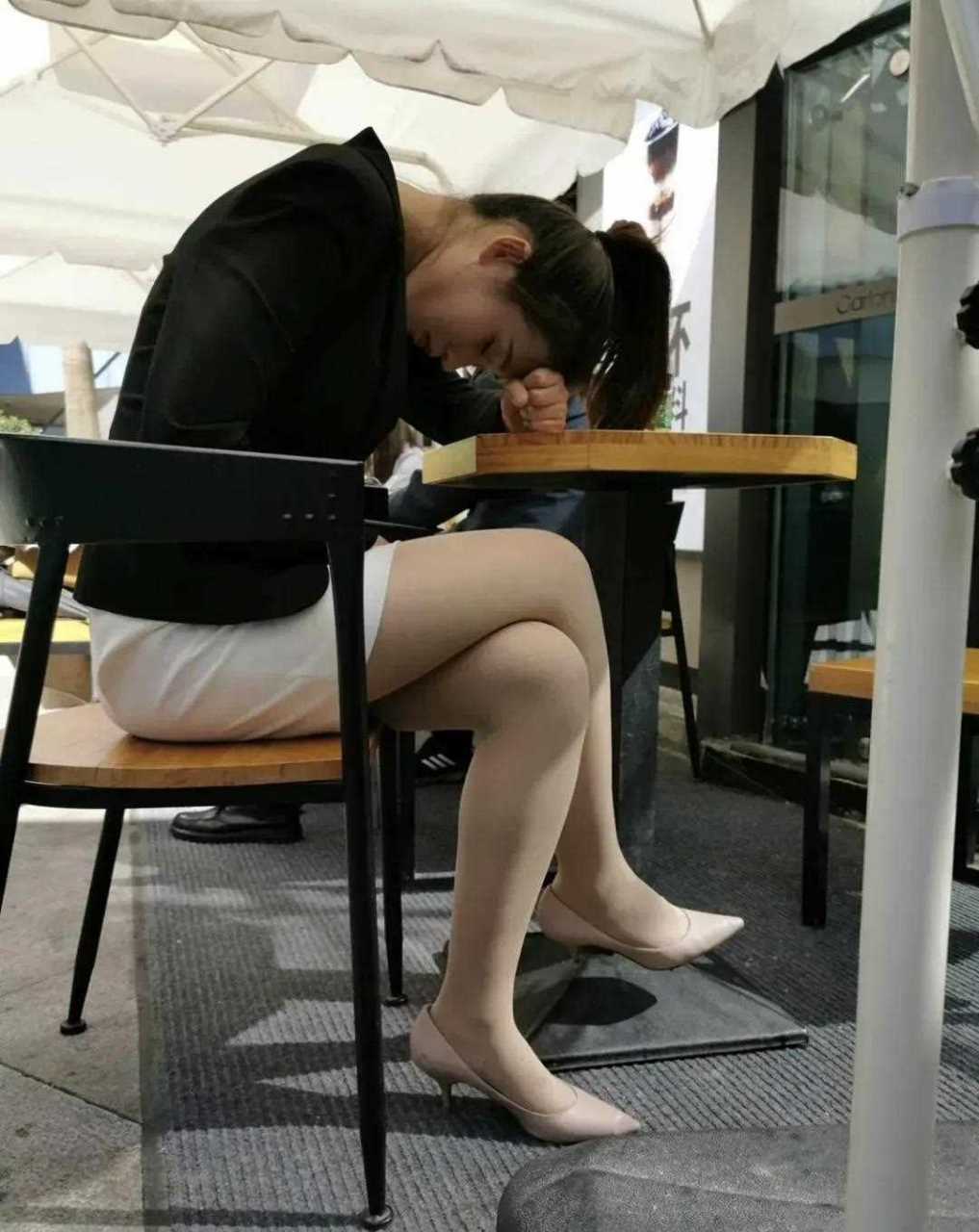 职业装美女穿丝袜裙子西装外套高跟鞋坐在奶茶店门口休息