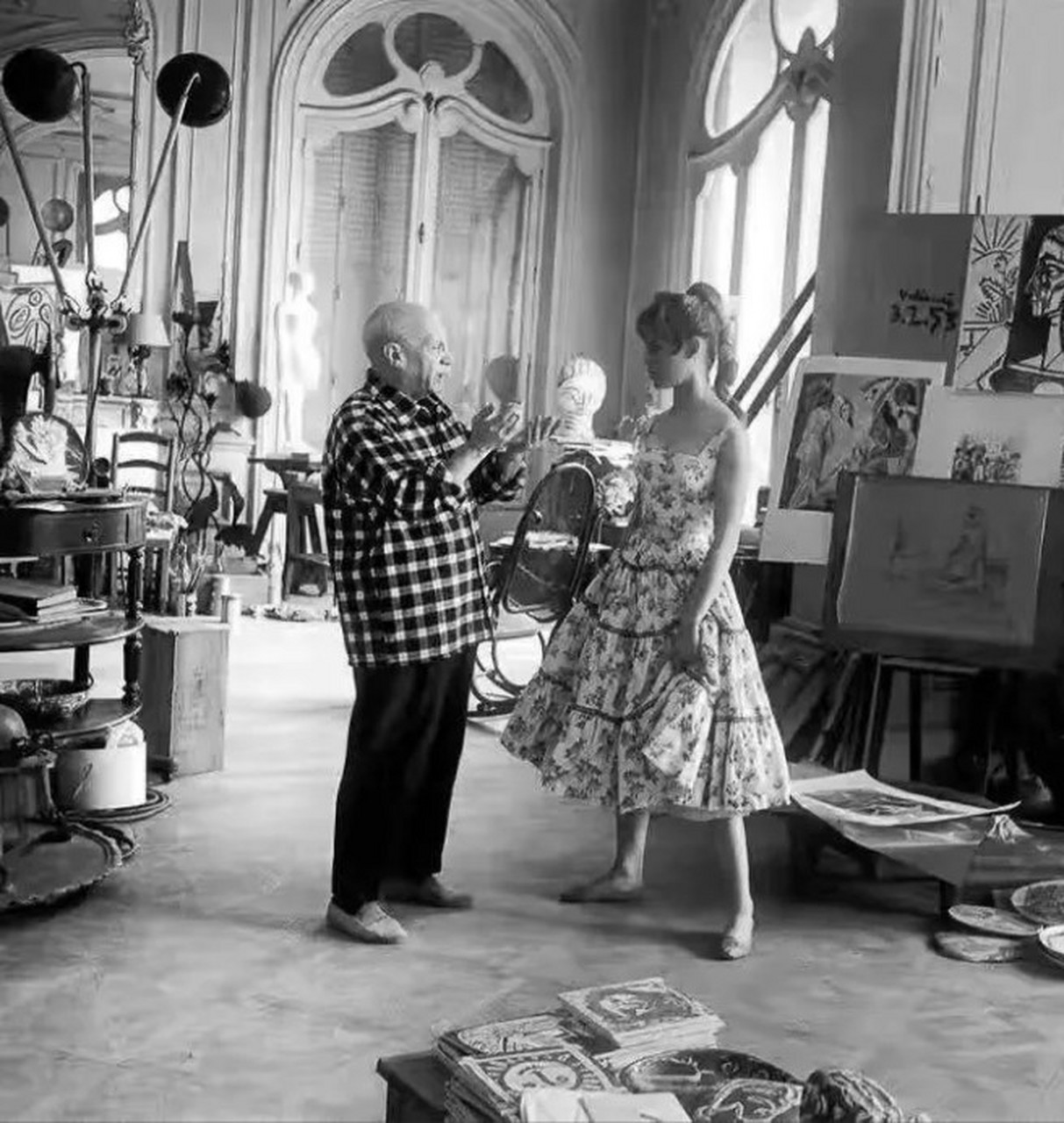 1956年,在法国戛纳毕加索家中,21岁的碧姬·芭铎在一旁听75岁的毕加索