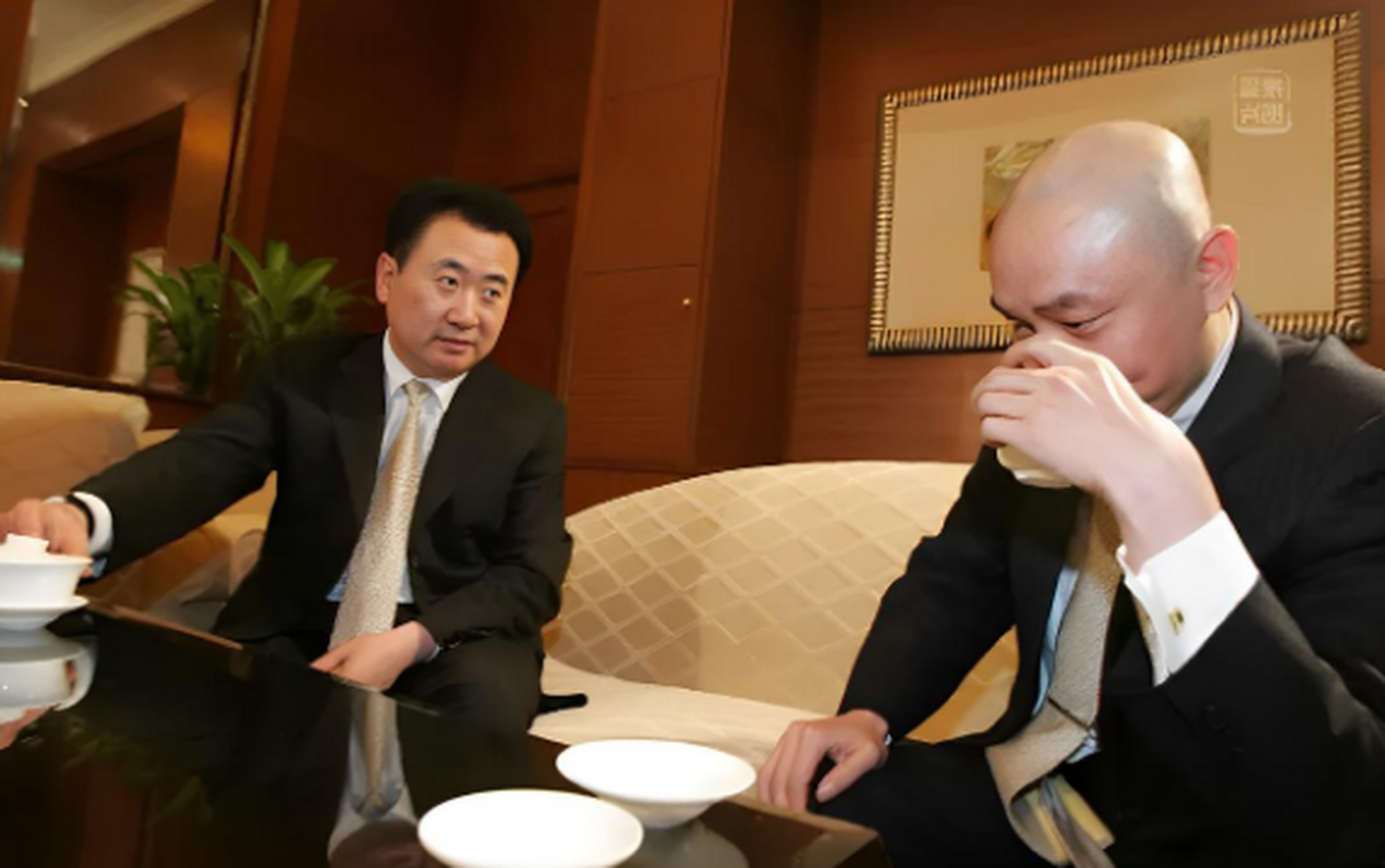 他和王健林坐在一起品茶谈话,黄光裕安静地听着王健林讲话,而王健林