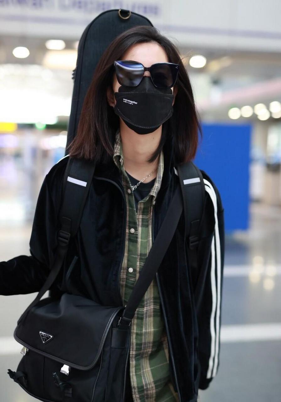 庄达菲机场街拍,黑色运动服搭 铅笔裤,背吉他酷飒十足