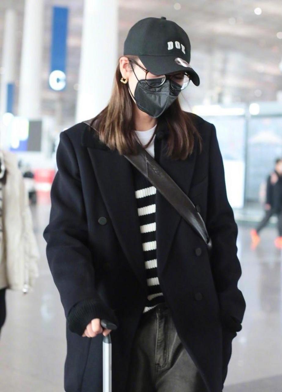 刘雯最新机场街拍,一身黑色大衣简约大气,搭配条纹针织衫 宽松牛仔裤