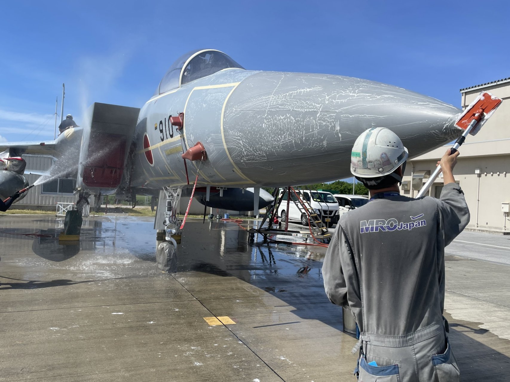 在那霸基地参观.基地工作人员正对一架f-15战斗机进行外观清洗工作.
