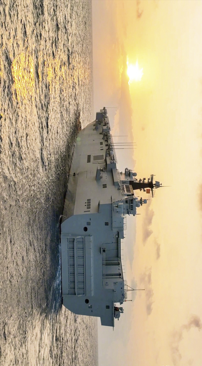 4万吨的075两栖攻击舰迎着朝阳出航,画面唯美,想起那首歌:"海风你轻轻