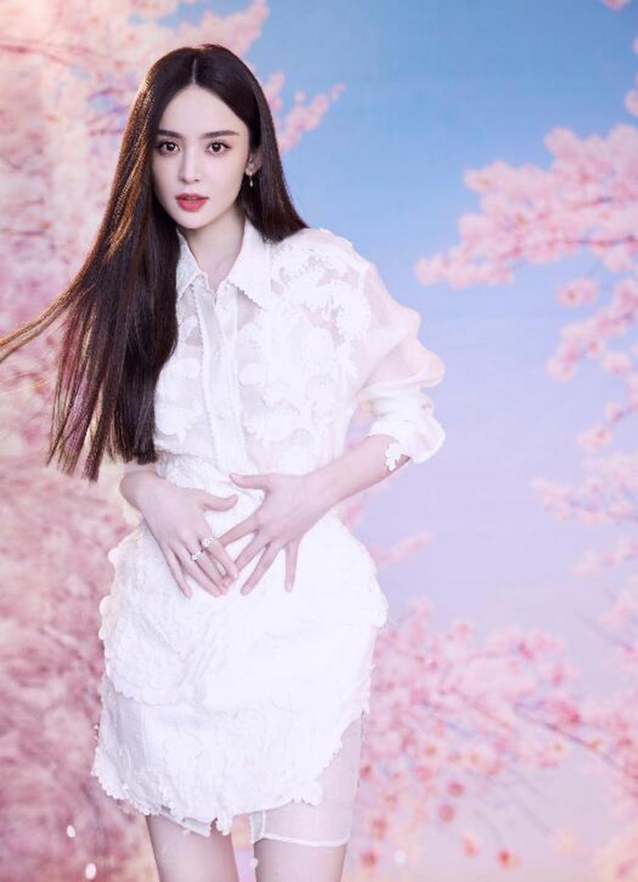 古力娜扎,镜头前或甜笑或双手捧脸卖萌,在樱花背景下美好治愈.
