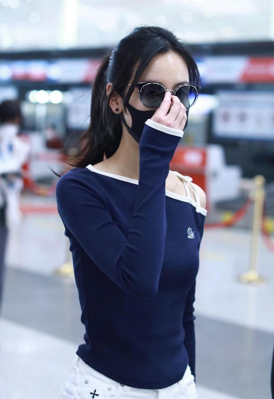 陈都灵机场街拍,蓝色斜肩t恤搭配白色喇叭裤,清爽苗条.