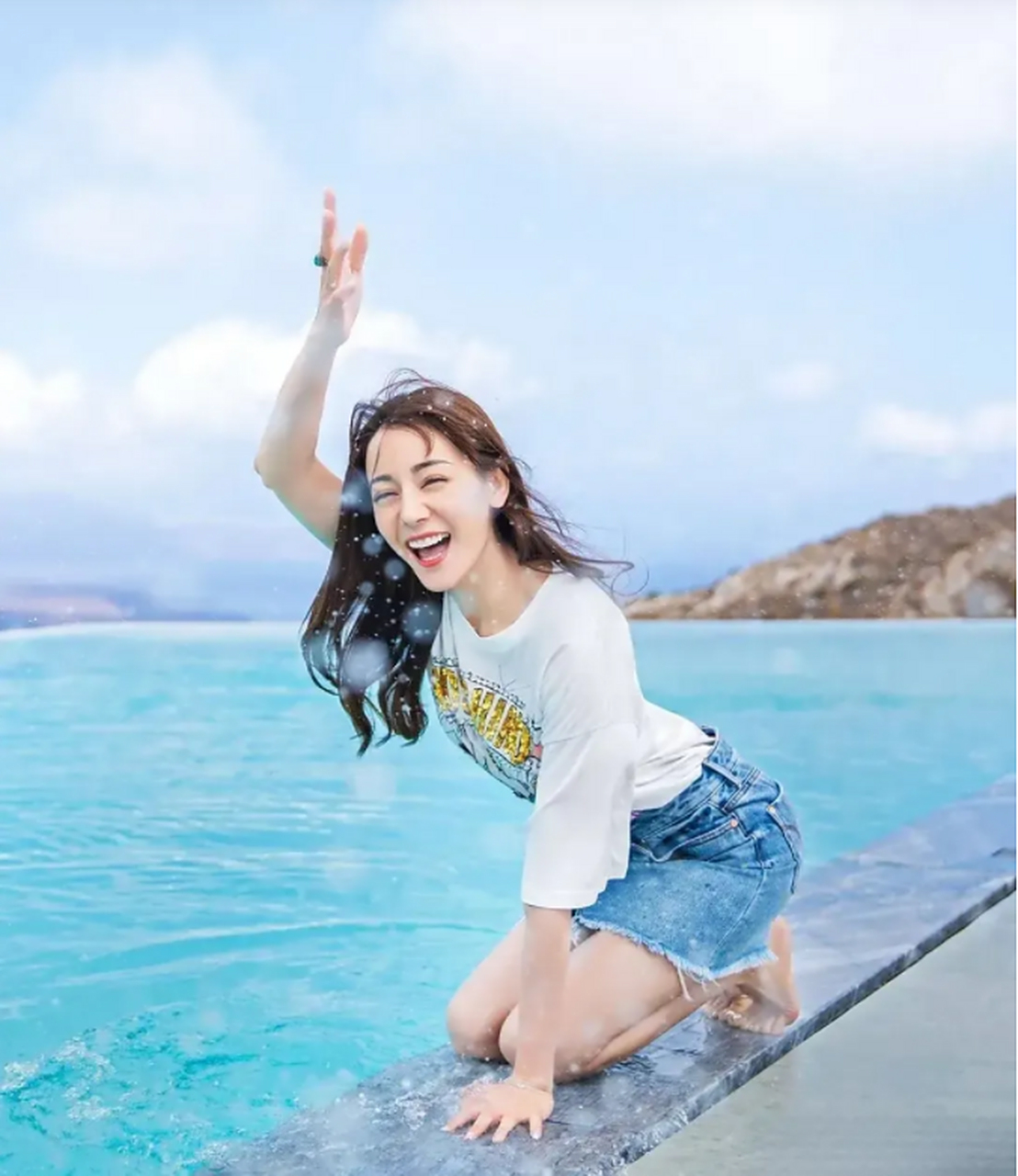 近日,迪丽热巴晒出一组海边风景照,图中:白色t恤,牛仔裙,吹着海风