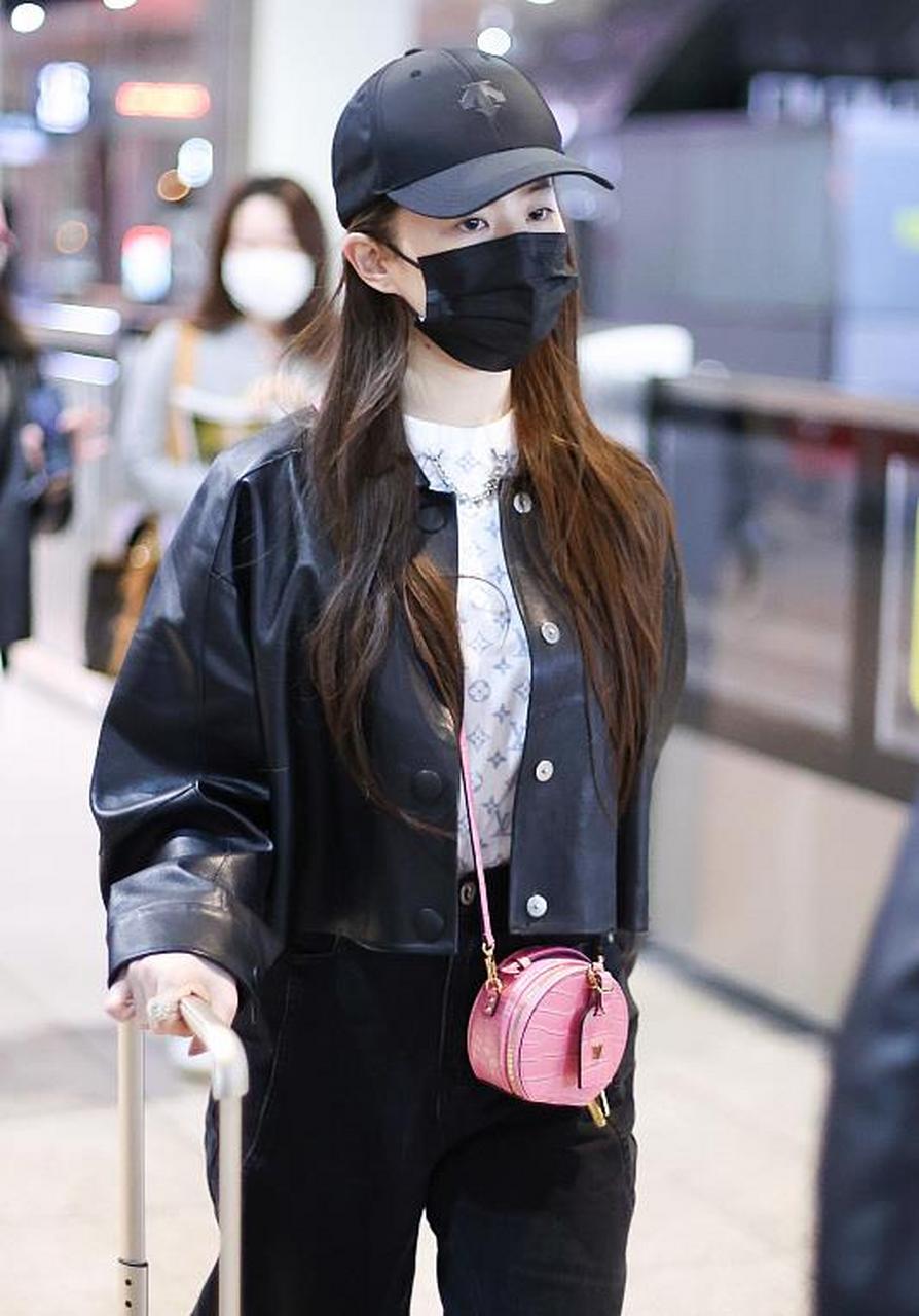 刘亦菲街拍,她穿了一件黑色的短款皮衣,内搭一件白色半高领的胸前印花