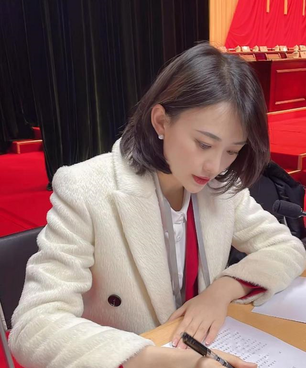 她对此非常认真,需要和参会人士一同封闭5天,穿着白色西装神态专注