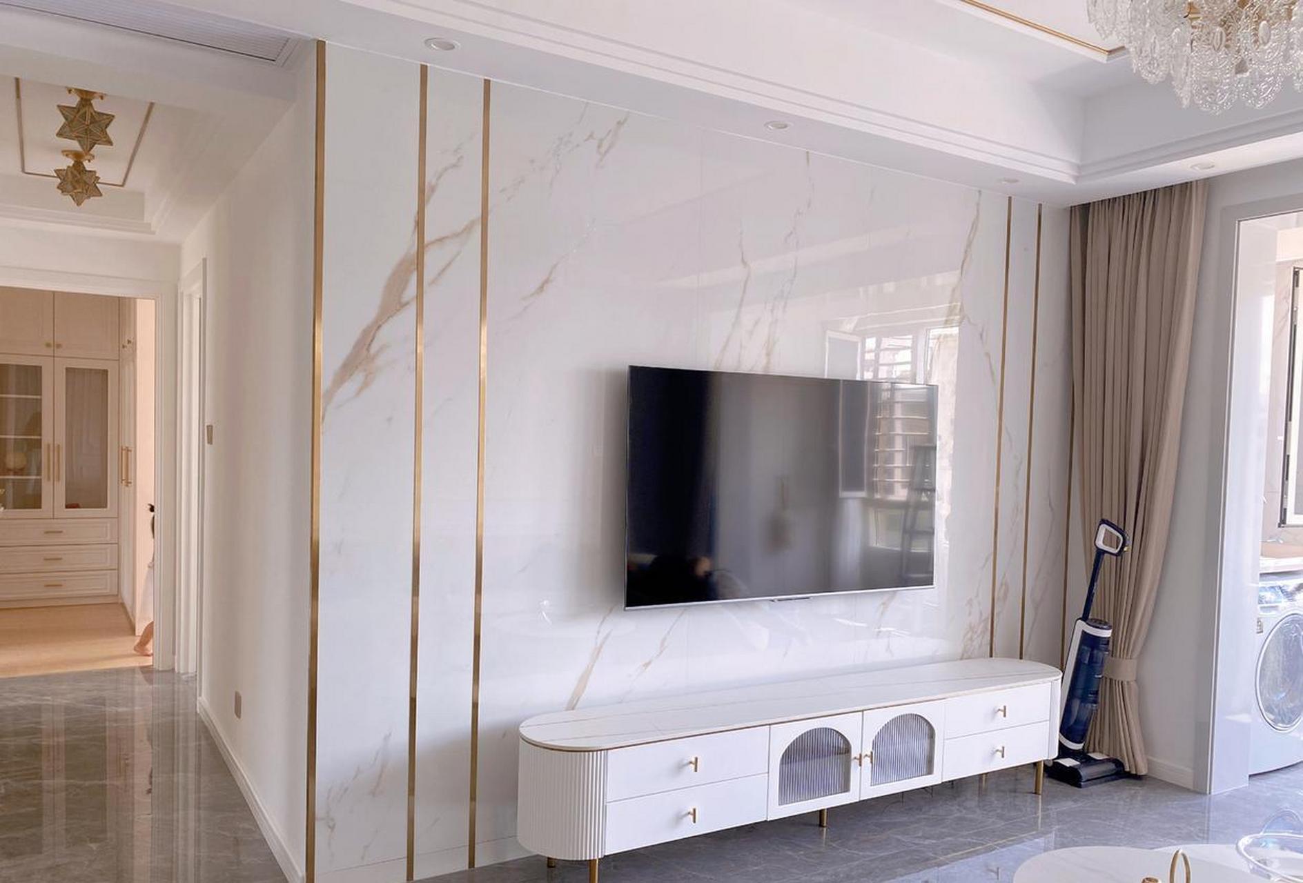 鱼肚白的岩板电视背景墙,配上钛金线条,满满的轻奢质感.