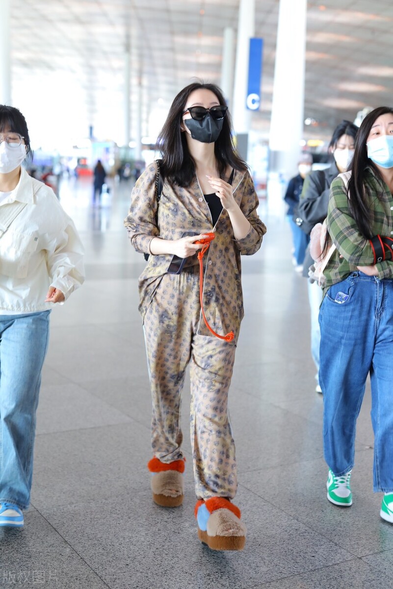 张靓颖机场街拍,棕色印花连体裤搭配毛绒拖鞋,随性休闲!