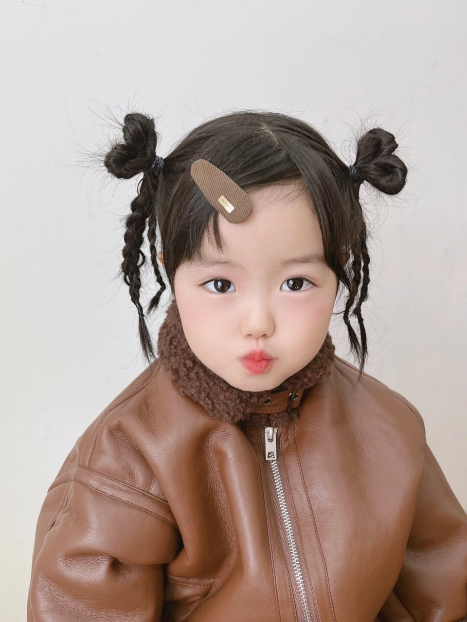 是爱心麻花辫女孩呀   阳光下,一位可爱的女孩梳着两个俏皮的爱心麻花