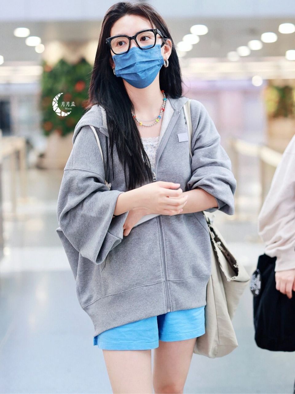 章若楠现身机场的休闲穿搭 身穿灰色连帽拉链卫衣, 搭配蓝色短裤 小白