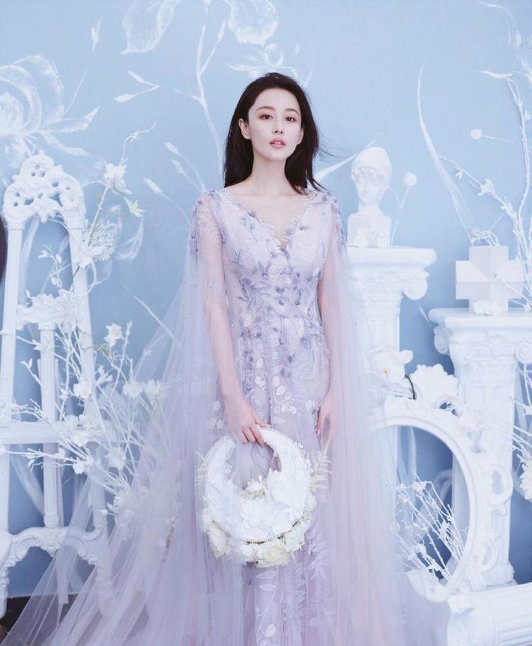 张馨予一袭浅紫色的轻纱礼裙,精致的镂空,水钻,让这套礼裙显得高贵