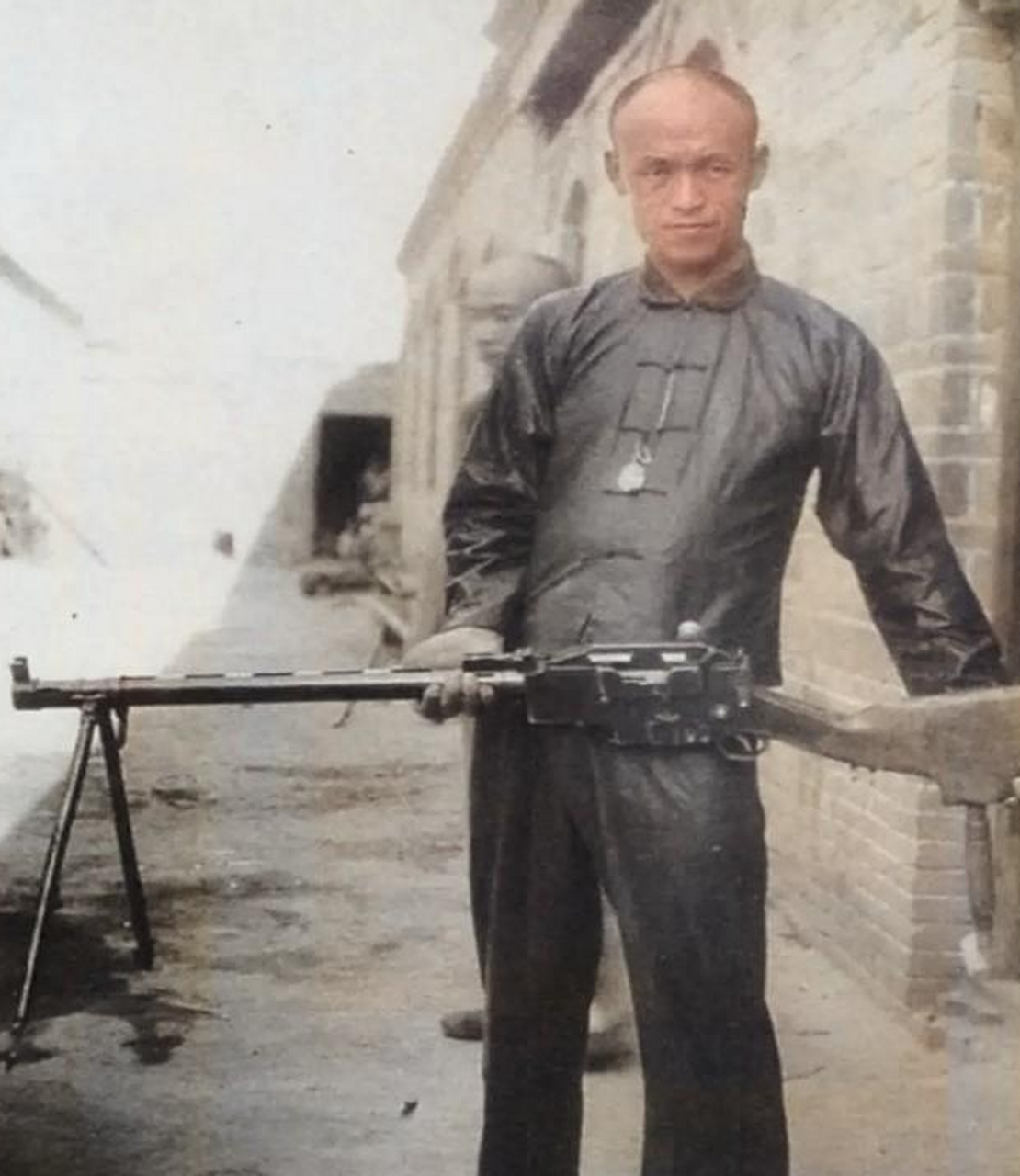 一名身材消瘦的男子看起来好像手无缚鸡之力,他吃力地端着一把当时