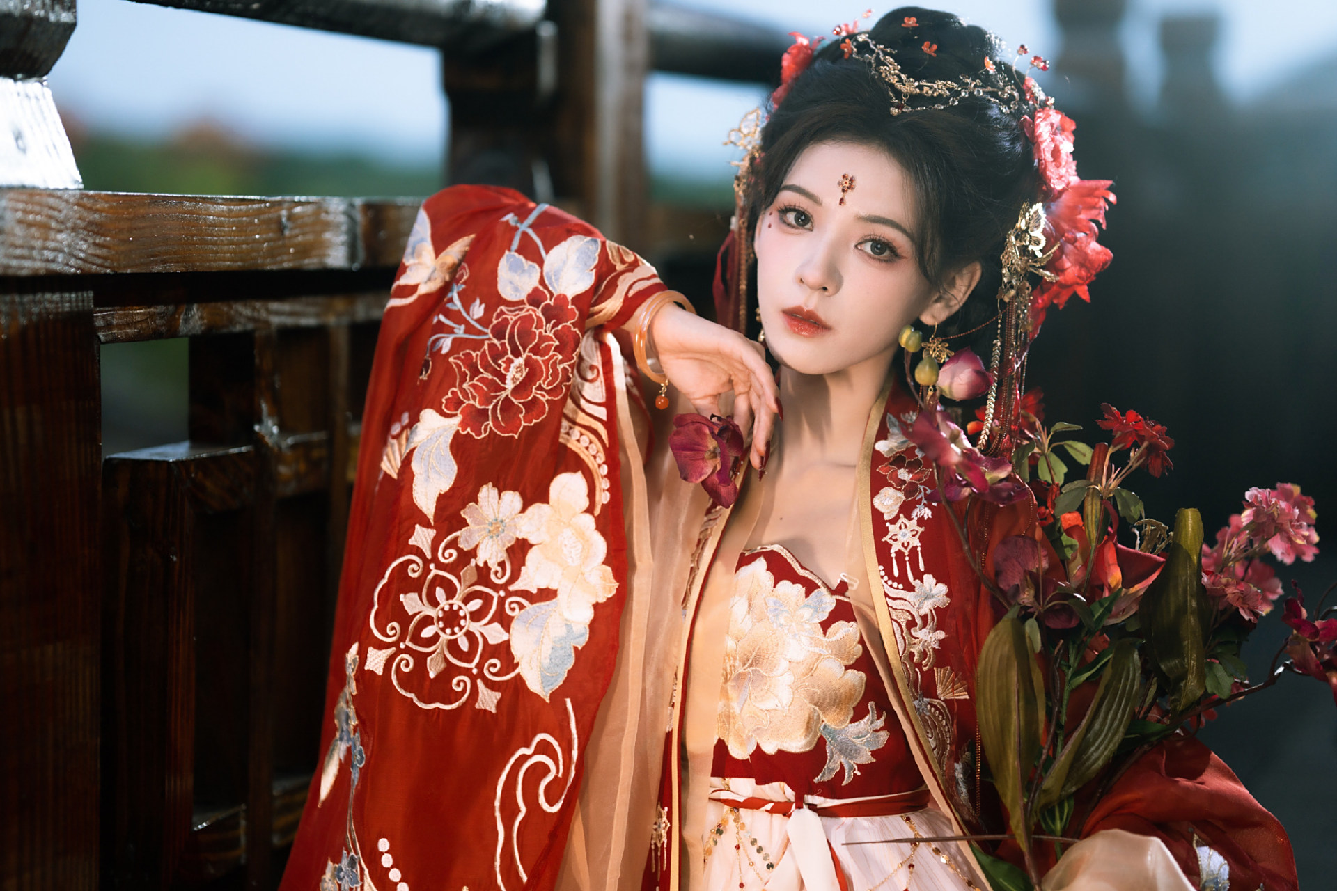 张予曦的一组古装美照曝光,她身穿红衣佩戴红花妆容精致,手捧花束娇艳