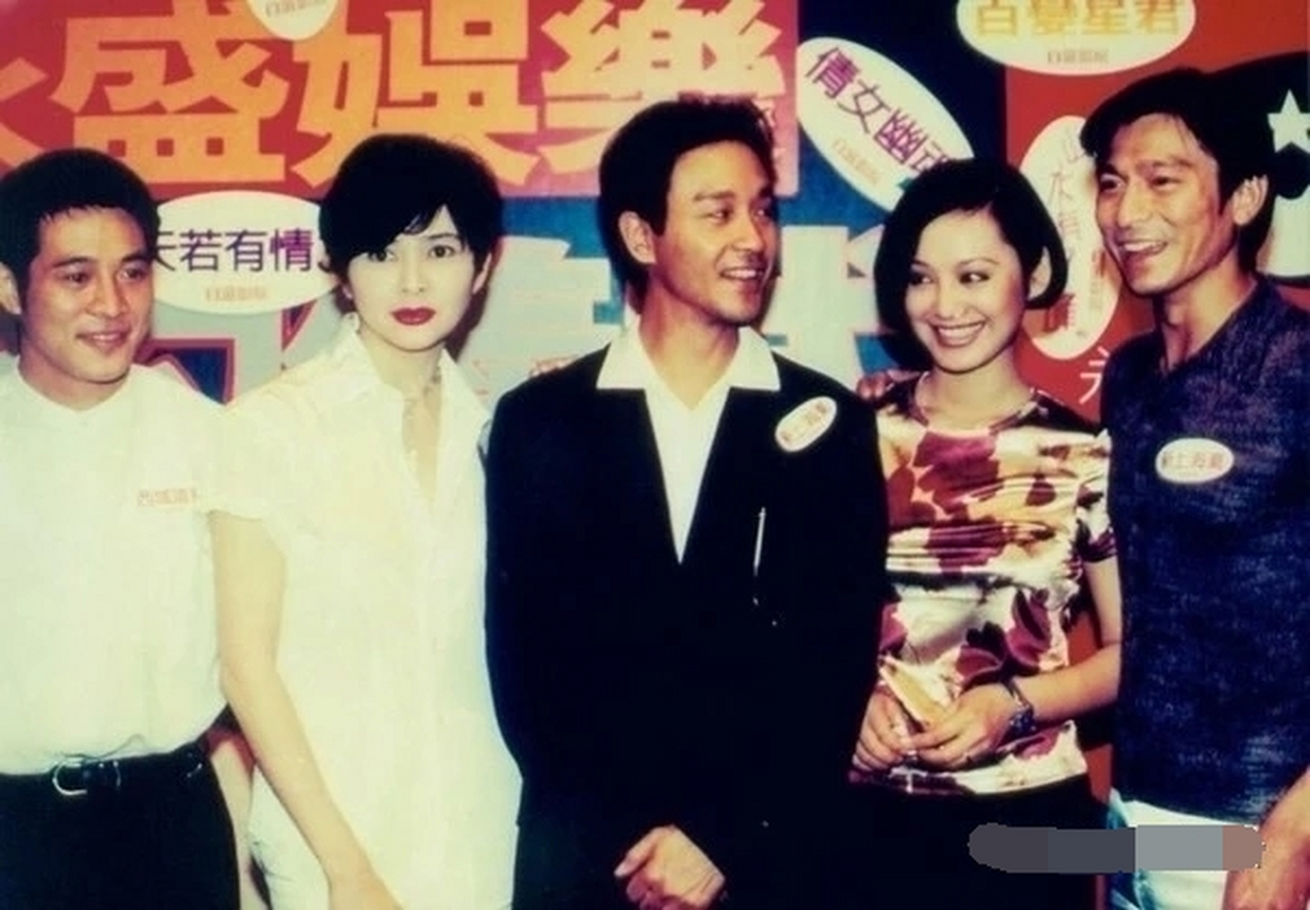 李连杰正常微笑,侧身,眼望左前方,双手放在身后.