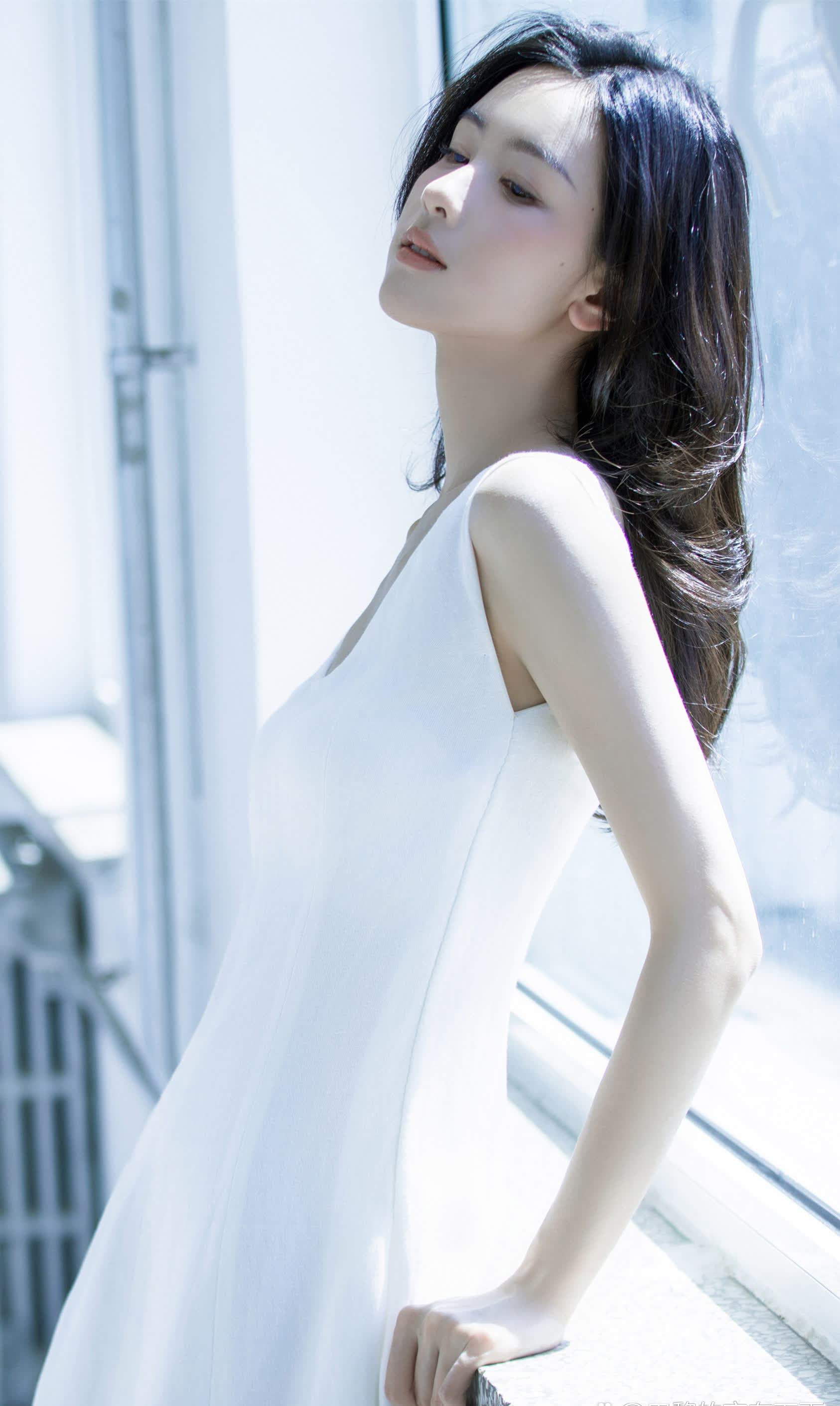 陈都灵身着一件优雅的浅白色连衣裙展现出夏日少女的甜美风情
