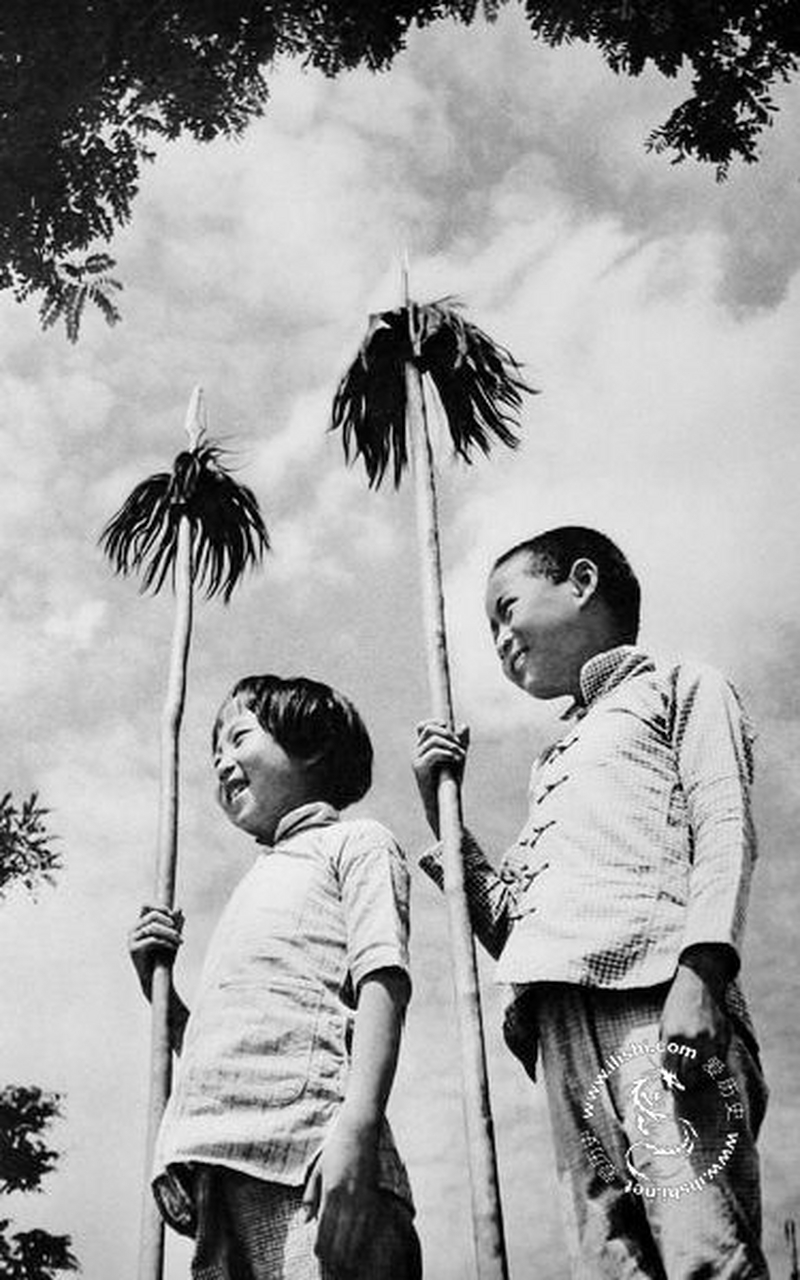 抗日战争时期两个孩子拿着红缨枪的照片,今天我们的笑容都是抗日先辈