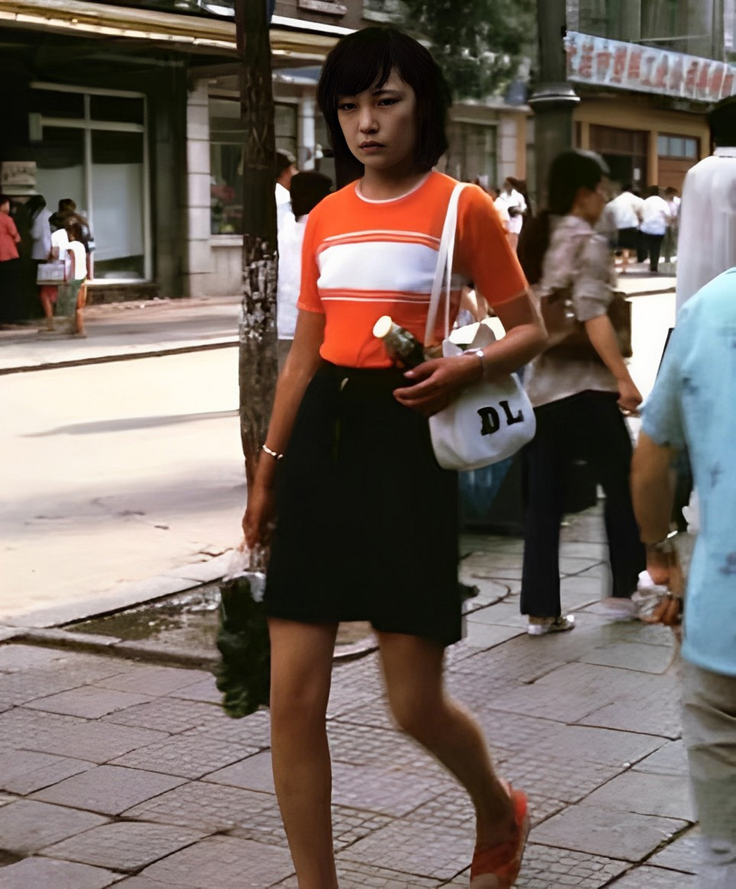 上世纪80年代上海的一张老照片中,几个穿着时尚的女孩打着油纸伞在