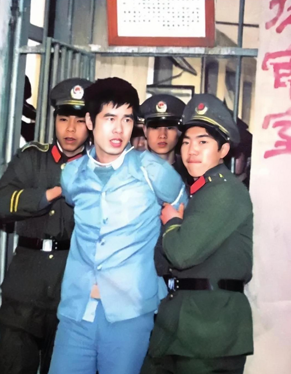 历史老照片: 年轻帅气的面庞,精致的五官,可他却被一众武警押解着
