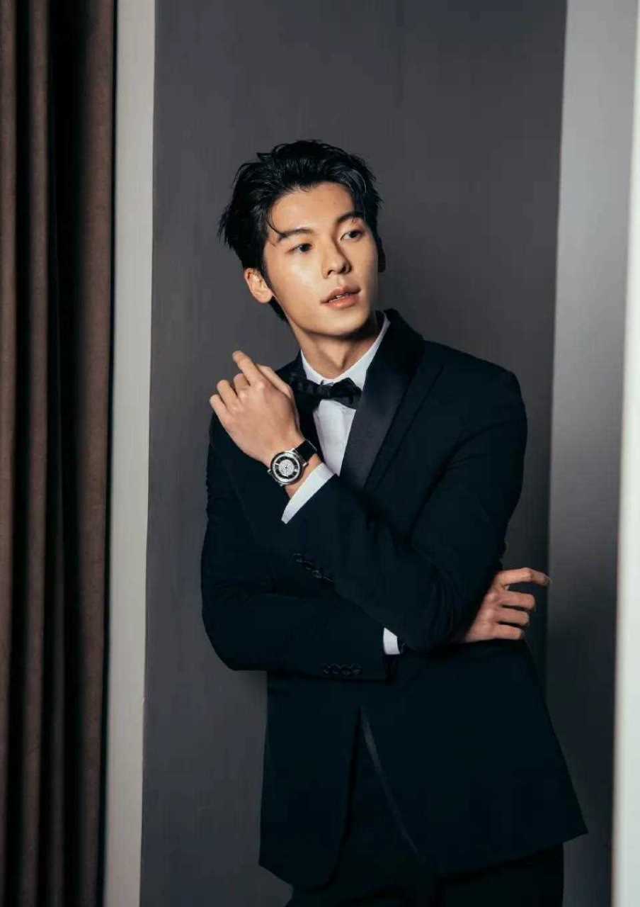 许光汉身穿经典的黑色西装搭配白色衬衫和点睛的黑色领结,成熟稳重不