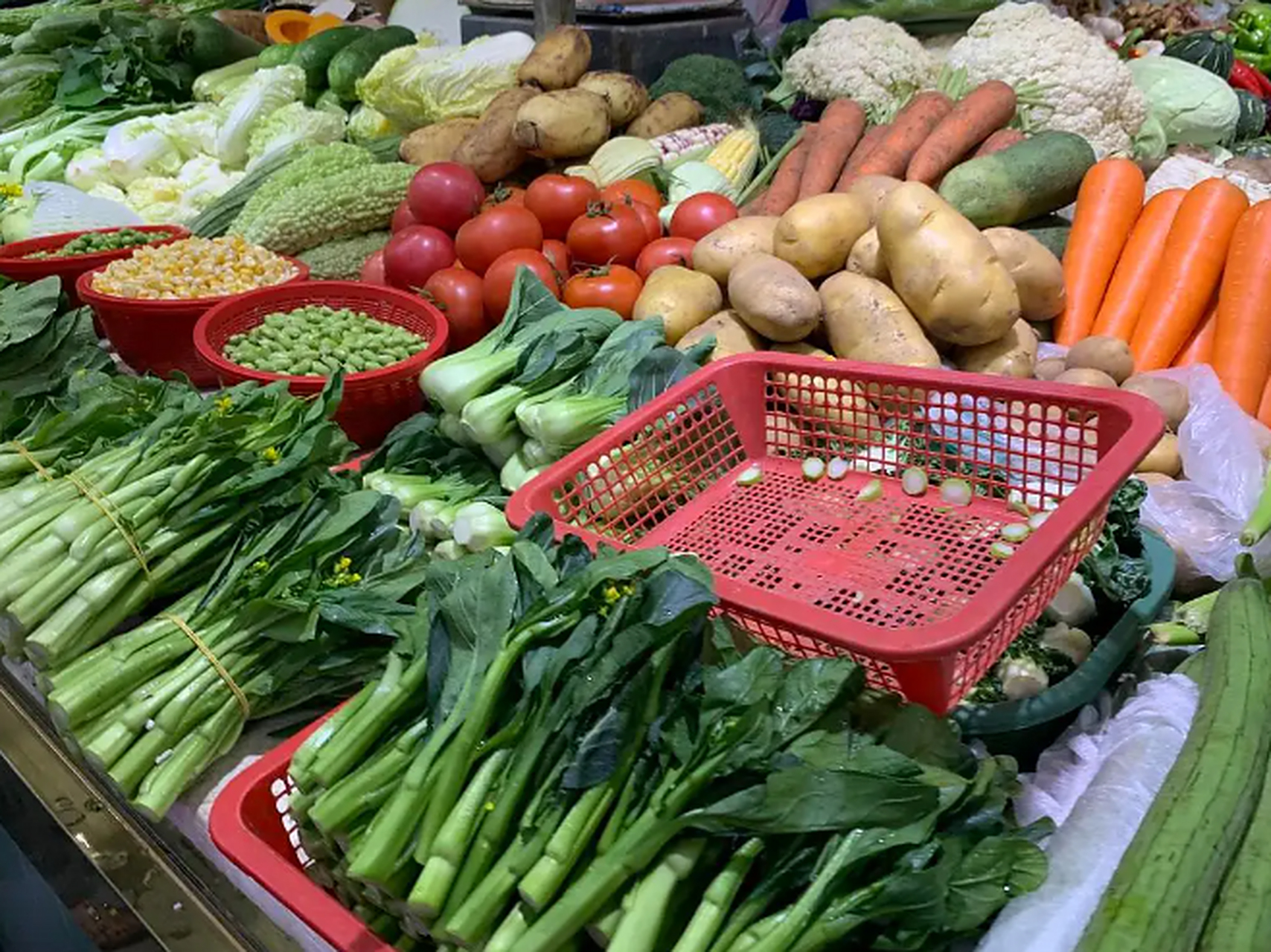 走进莲花菜市场,菜品整齐划一地摆放在一米高左右的架台上,架台下方的