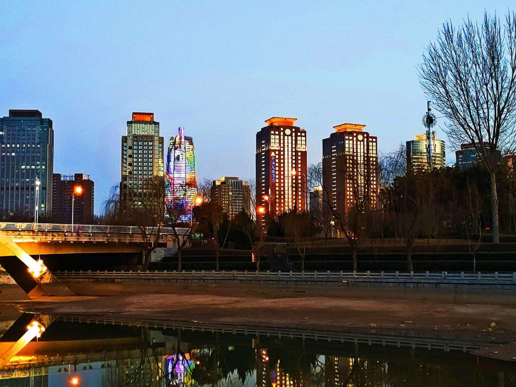 金水河畔漫步:金水河畔是郑州市区内的一条美丽河流,夜晚时分,河边