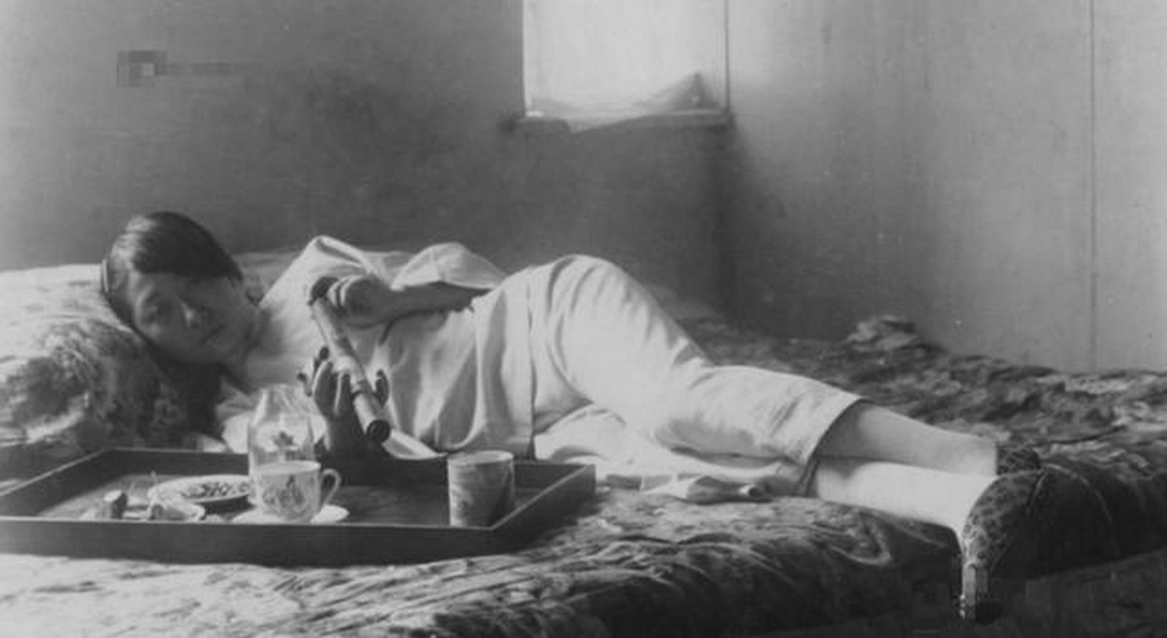九一八事变前夕,一名女子躺在炕上吸鸦片的照片,面部精神已经有些萎靡