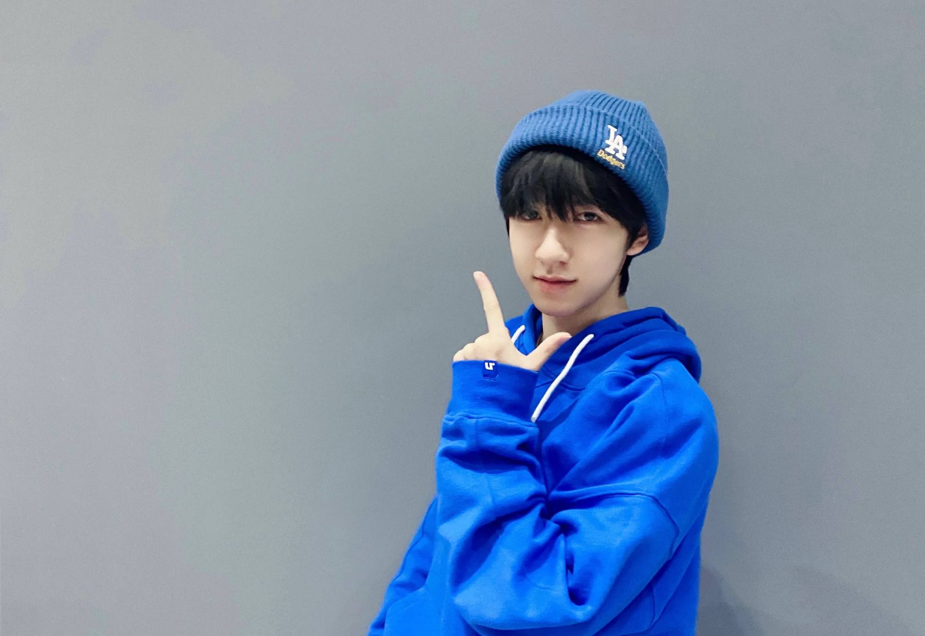 何俊霖分享了一张日常穿搭照,身穿宝蓝色字母印花连帽毛衣,搭配蓝色