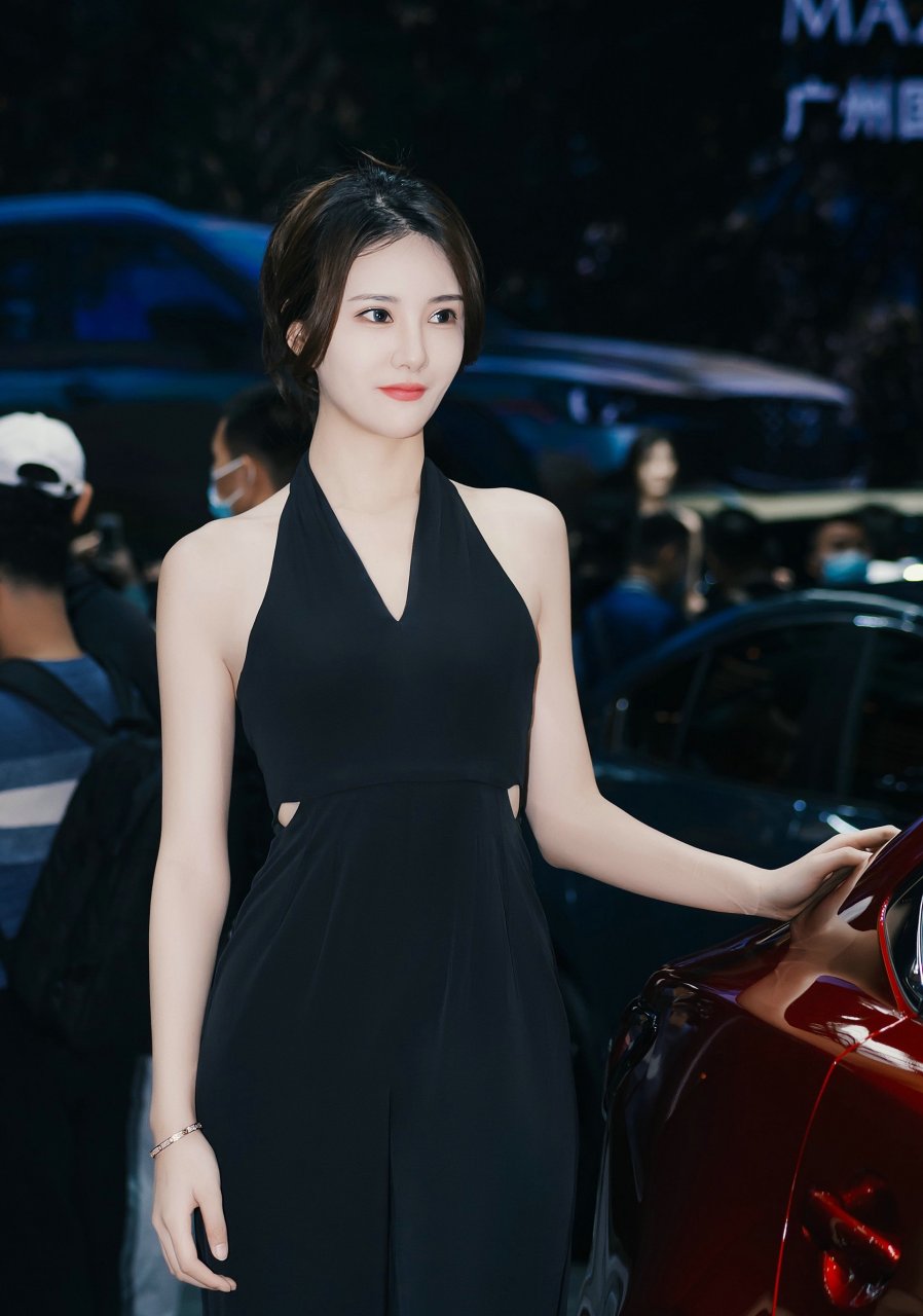 在车展上,那位漂亮的车模吸引了众人的目光.