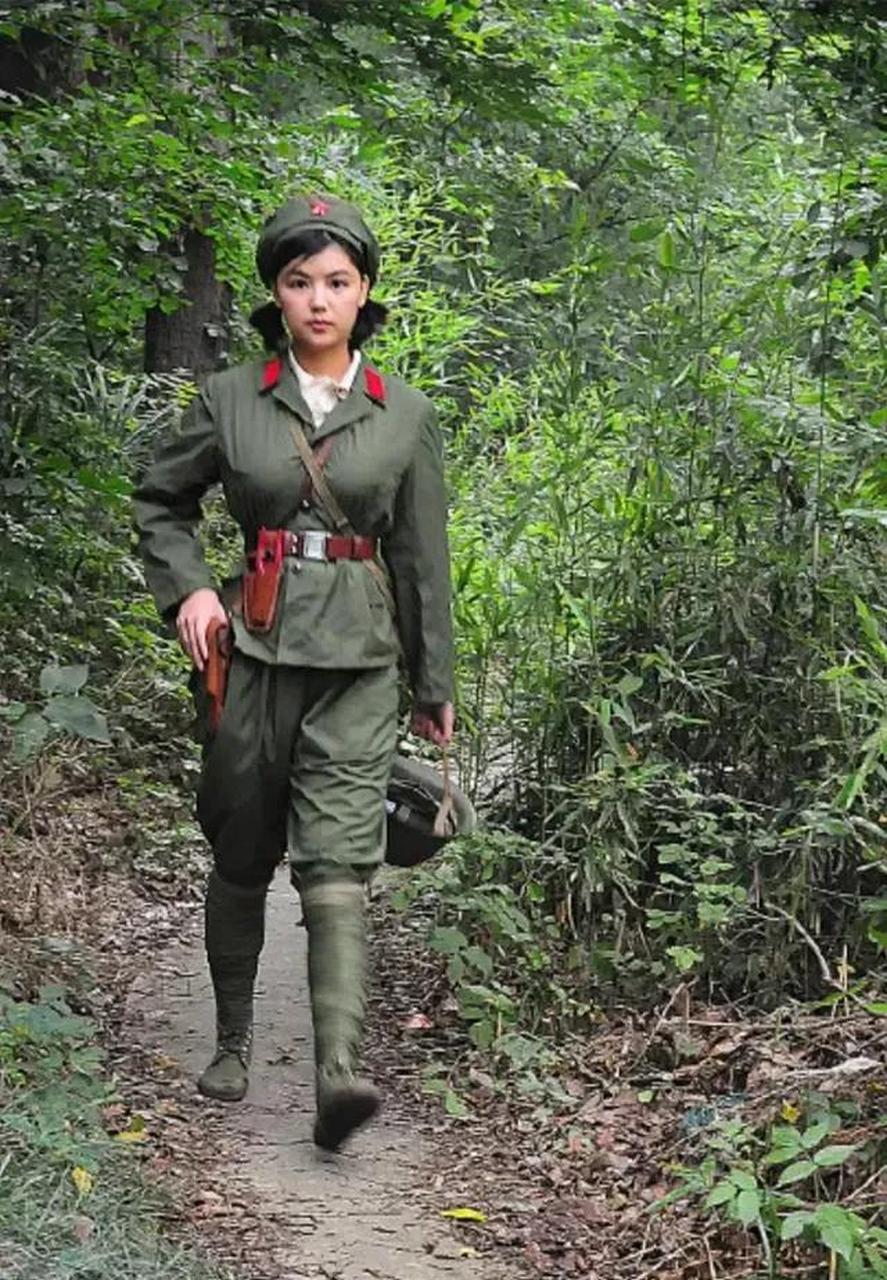 身穿65式军装,迈着坚毅的步伐,行走在山间小路的解放军女战士.